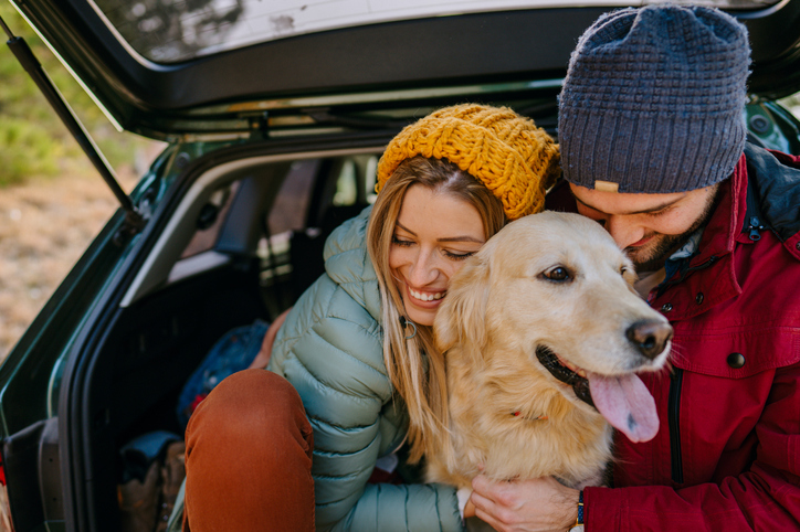 A couple cuddle their dog on a road trip to Whistler